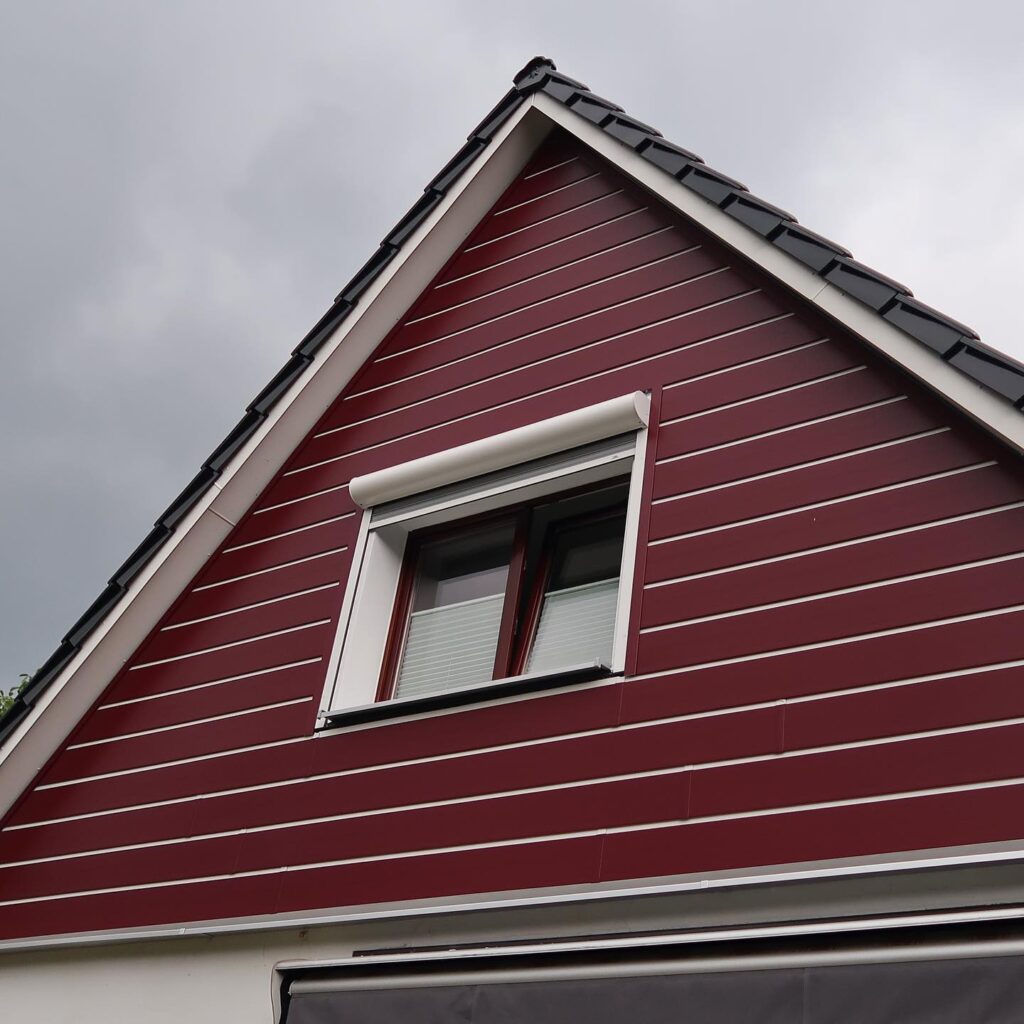 Dekora Fassadenprofil Dunkelrot genarbt mit weißen Schattenfugen - Sonderanfertigung für pflegeleichte Fassade